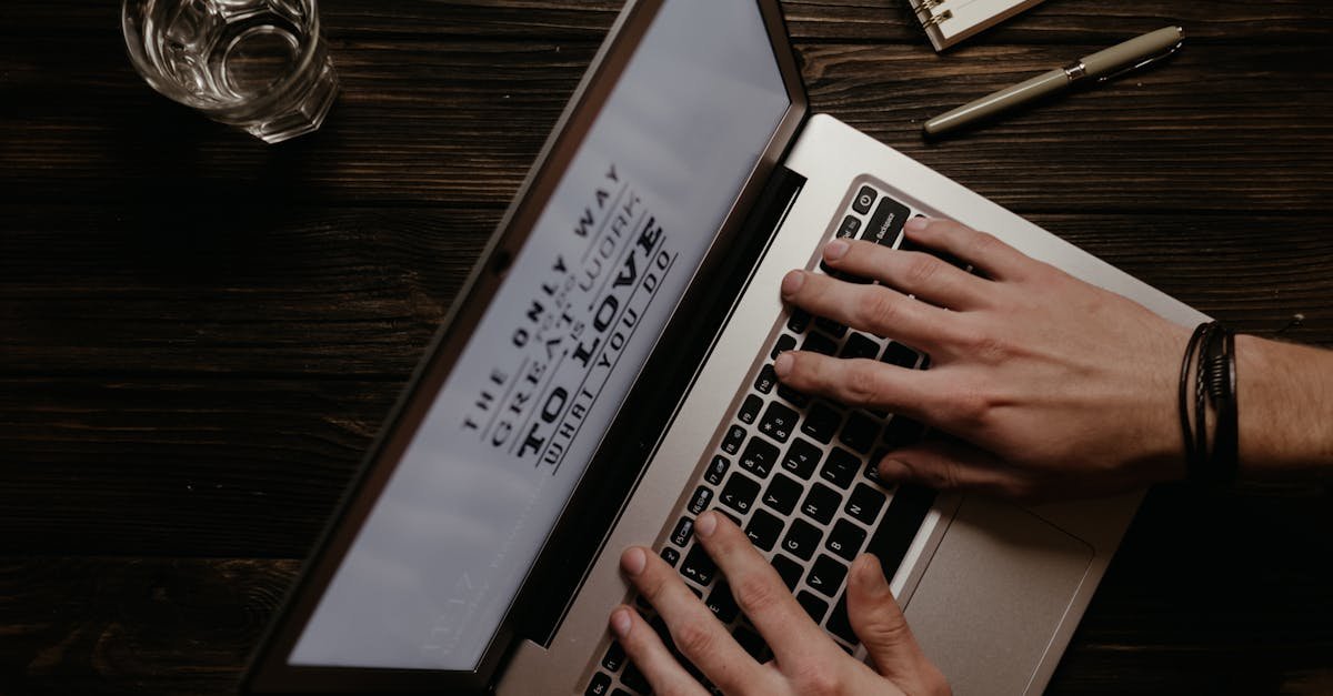 Hands on a laptop with an inspirational quote displayed on the screen, shot from above.